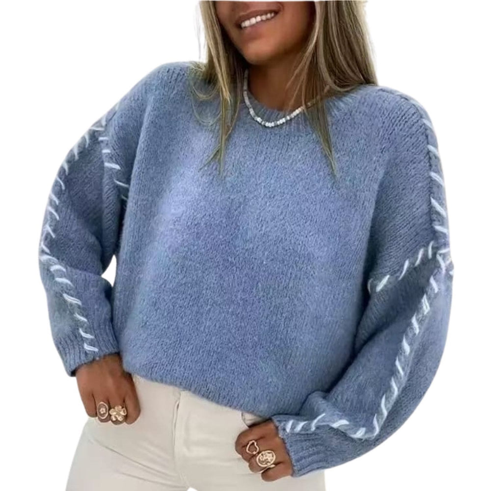 “Woman wearing a blue cozy knit sweater with braided sleeve detail and long sleeves.”