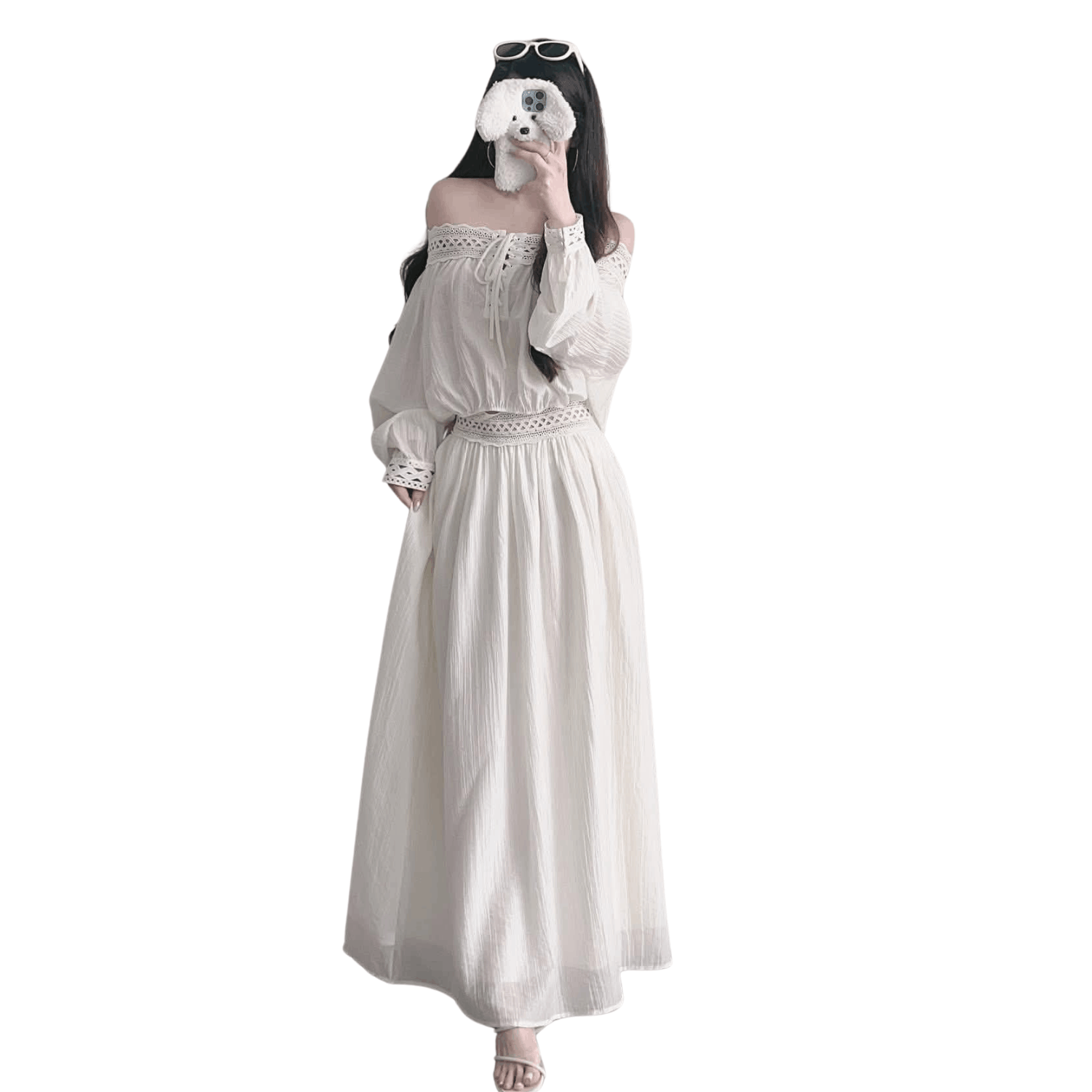 Woman wearing a white off shoulder two piece set with long sleeve crop top and flowy maxi skirt