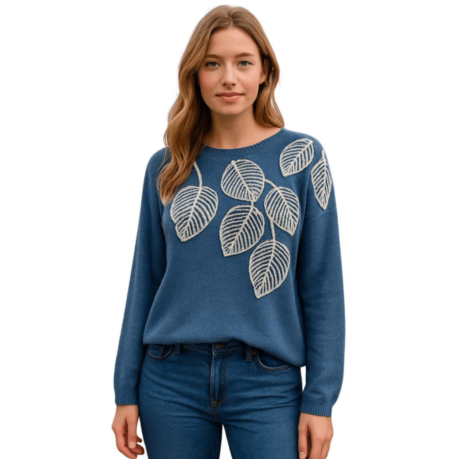 Woman wearing a blue knit sweater with embroidered leaf design on the front, paired with blue jeans