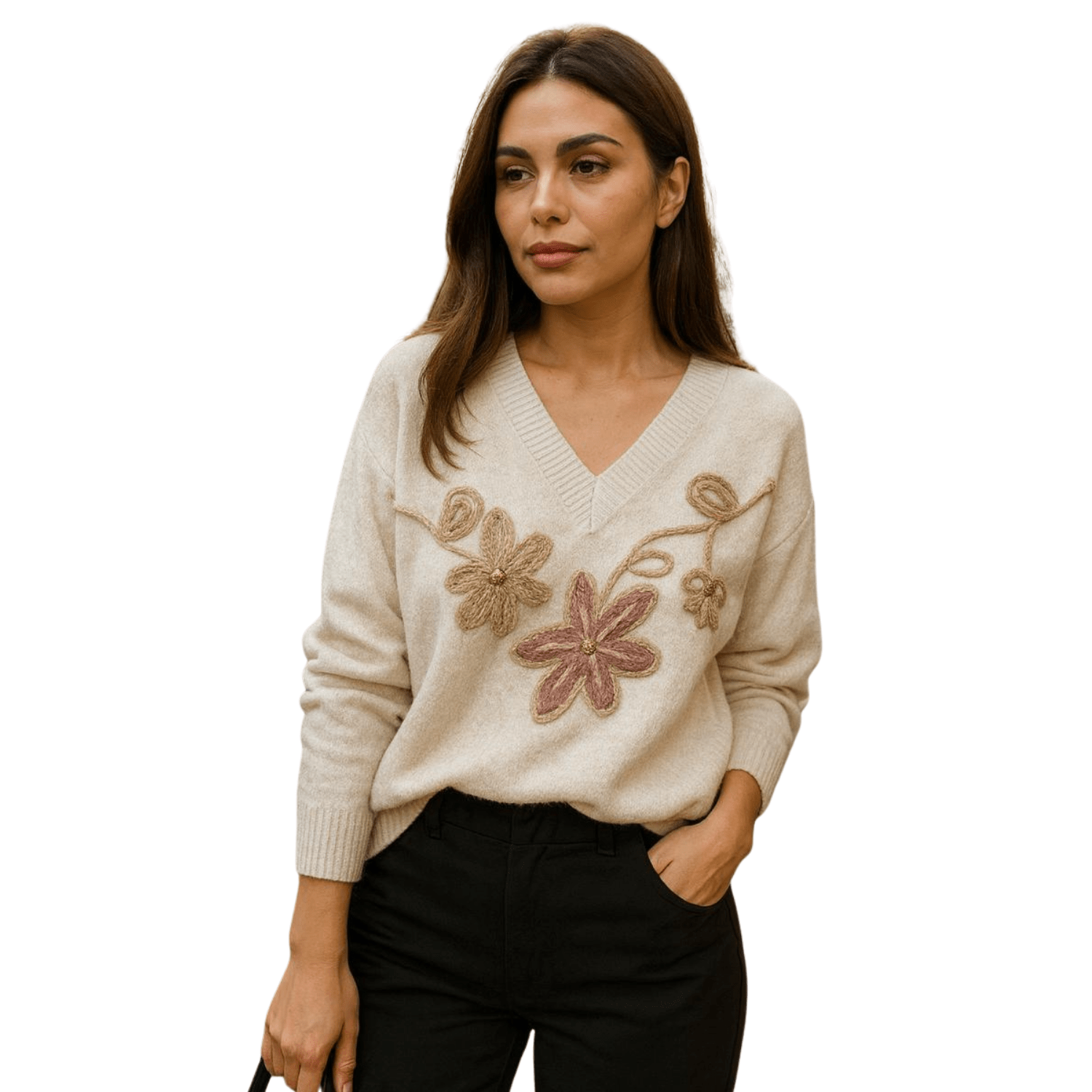 Woman wearing a cream V-neck knit sweater with embroidered floral detail on the front, paired with black pants