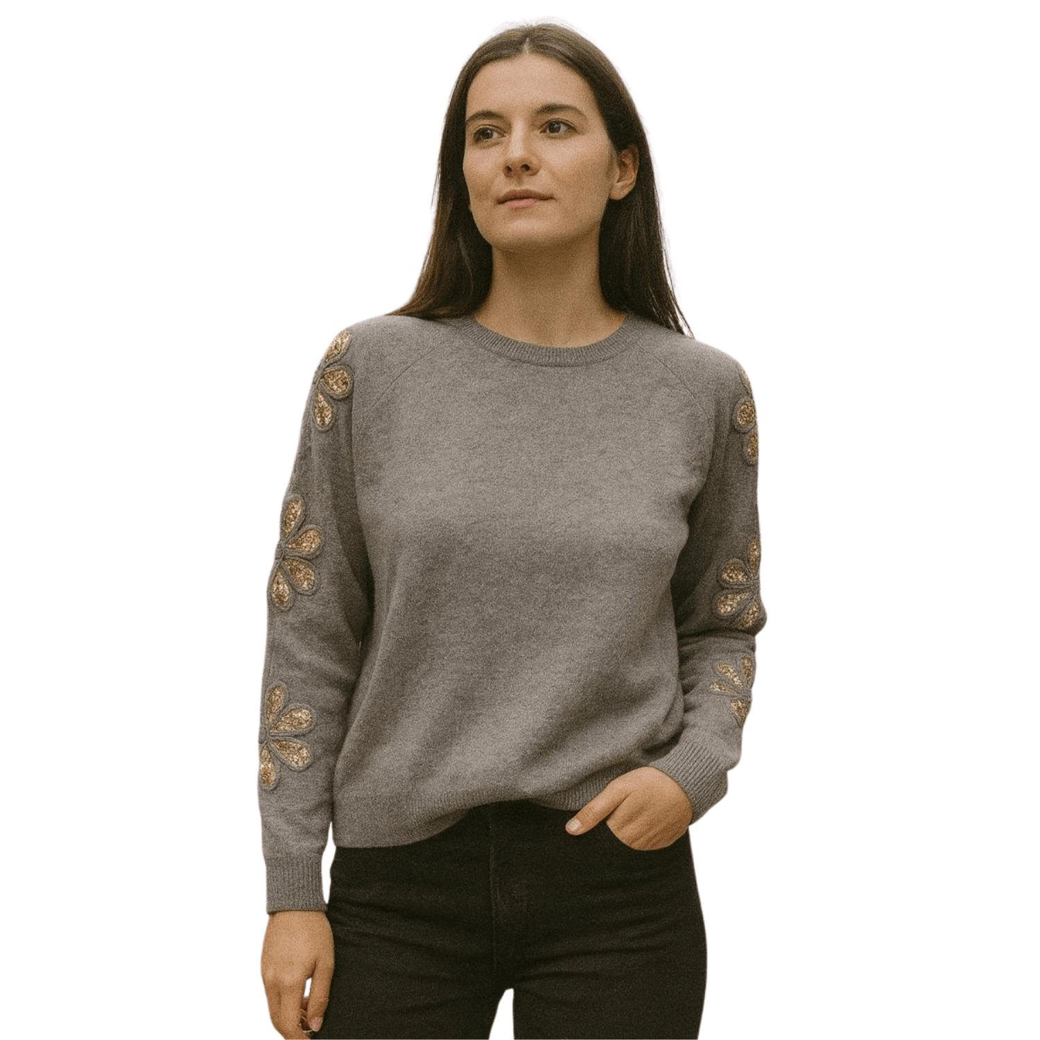 Woman wearing a gray knit sweater with gold embroidered floral details on the sleeves, paired with black pants