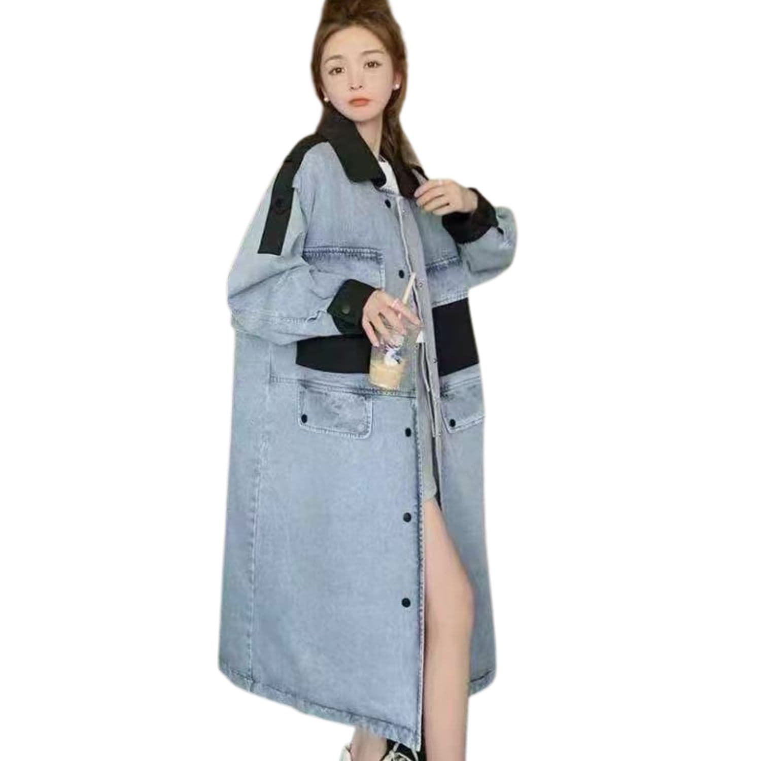 “Woman wearing a long light-wash oversized denim coat with black details and button front.”